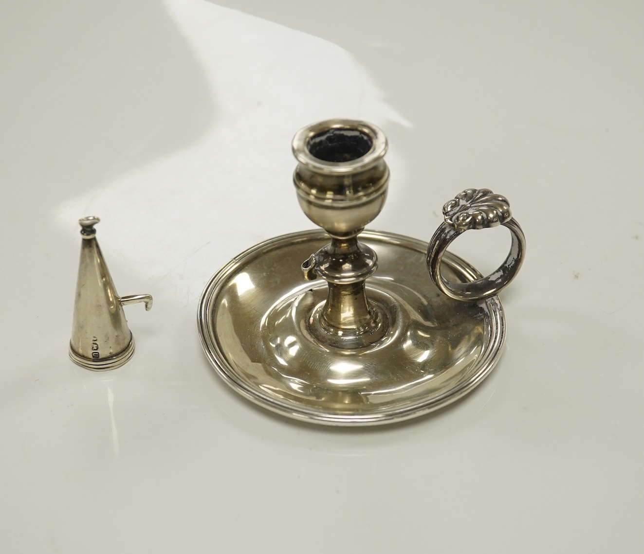 A George III miniature silver chamber stick, Emes & Barnard, London, 1815(a.f.), with matching extinguisher, base diameter 75mm. Condition - poor